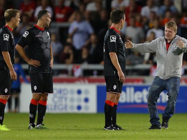 We're glad you're here. A fan greets Gary Neville and friends during a friendly at Salford City