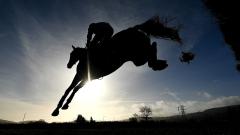 Horses leaping over a hurdle at Ascot